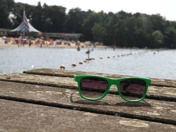 Eine grüne Sonnenbrille auf einen Holztisch 